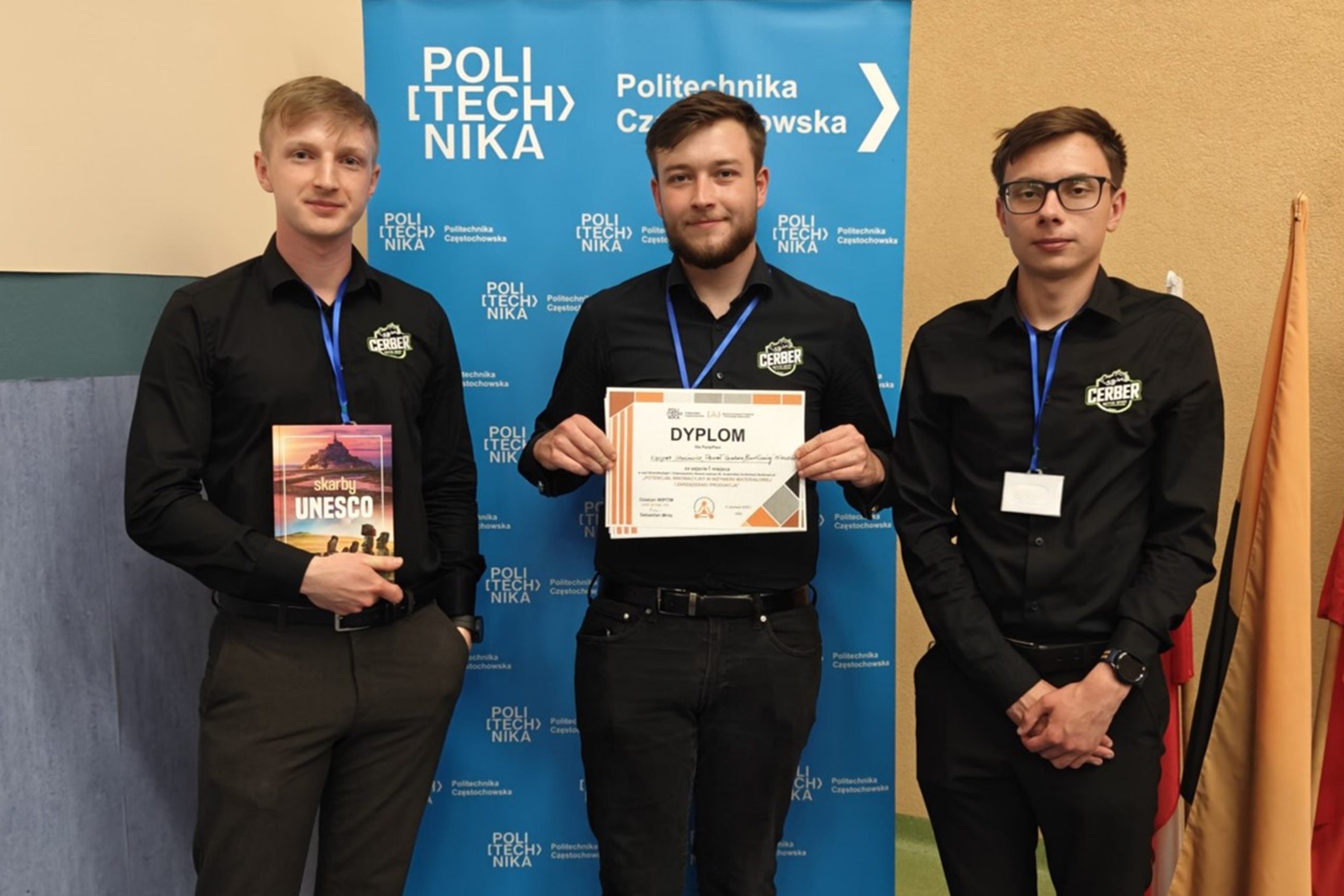 trójka studentów na konferencji, w tle baner reklamowy