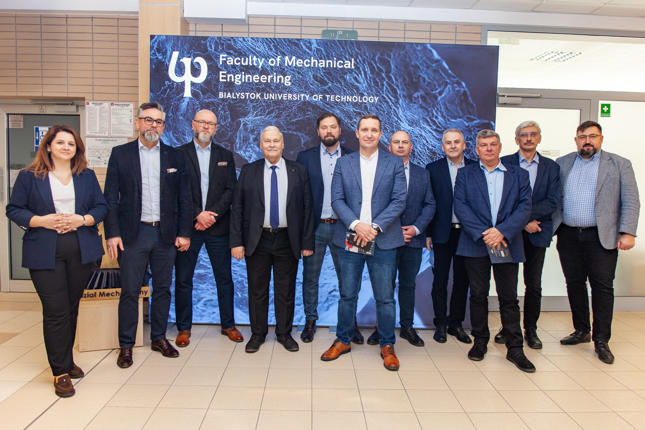 Zespół członków sekcji na tle ścianki reklamowej